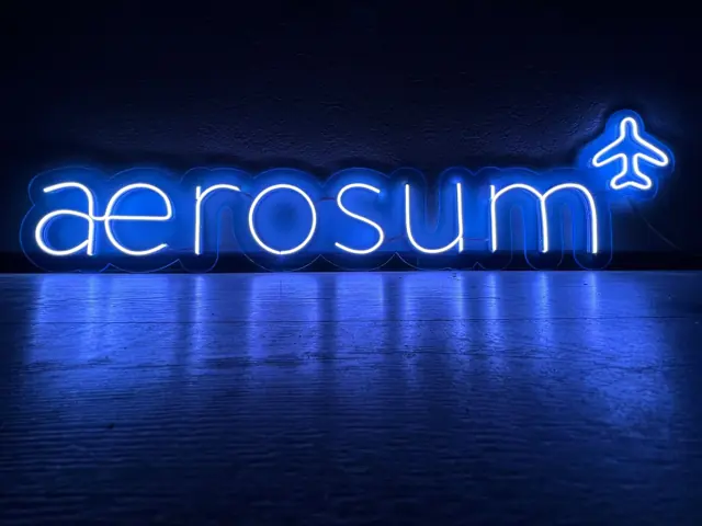 Mėlynas LED neoninis logotipas su lėktuvo simboliu